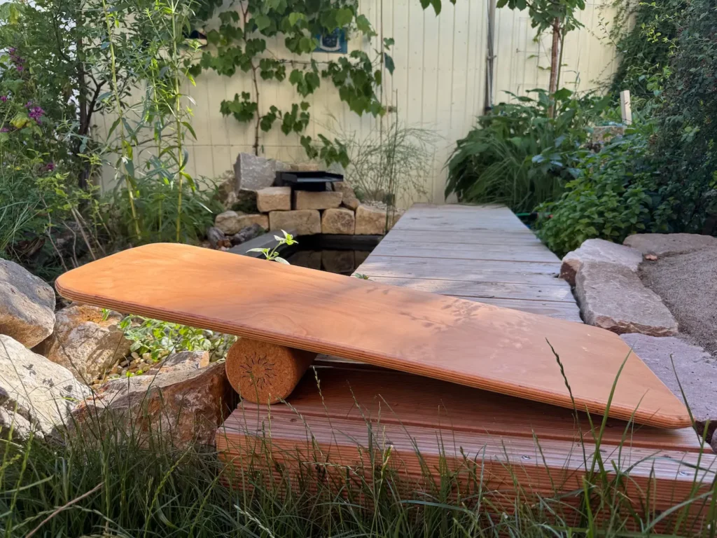 Ein Balance Board liegt auf einer Korkrolle.