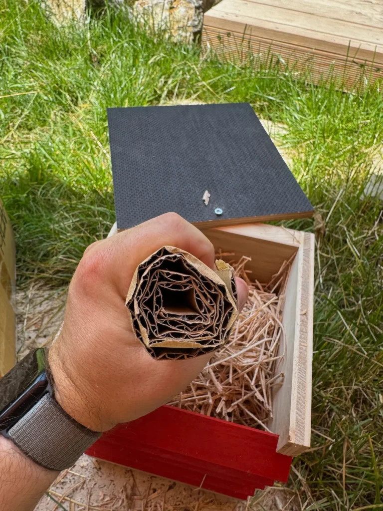 Eine Faust hält eine zusammengerollte Kartonage-Rolle.