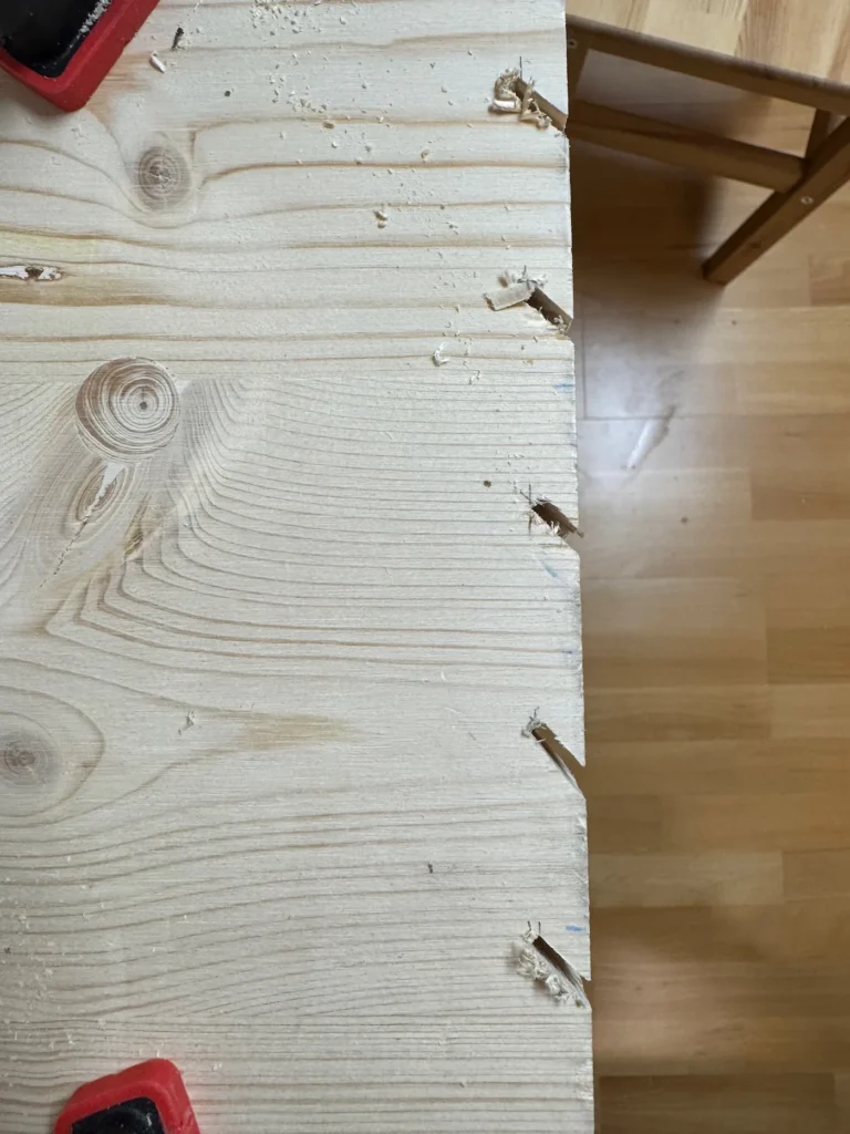 Eine Holzplatte mit mehreren gesägten Nuten.