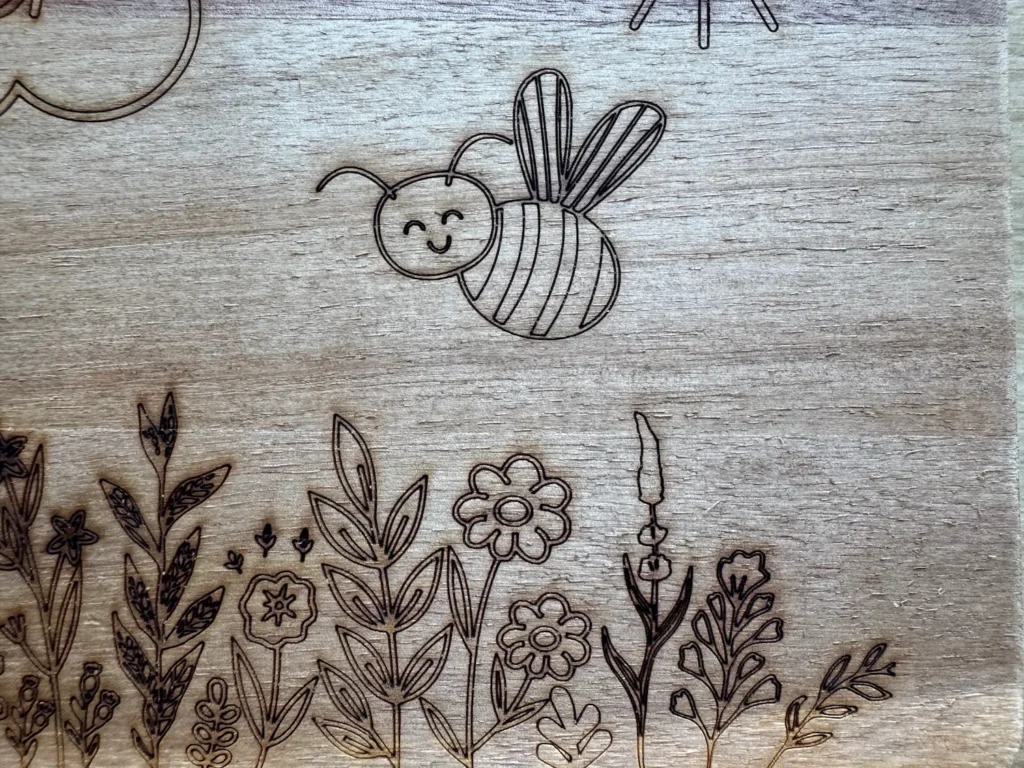 Detailaufnahme einer Holzgravur mit Blumen und einer kleinen Biene.