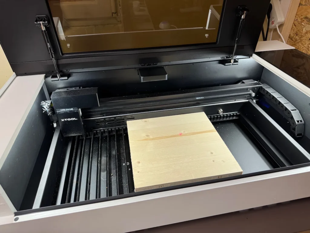 Arbeitsbereich des xTool P2 mit eingelegtem Holzstück zur Vorbereitung einer Gravur.