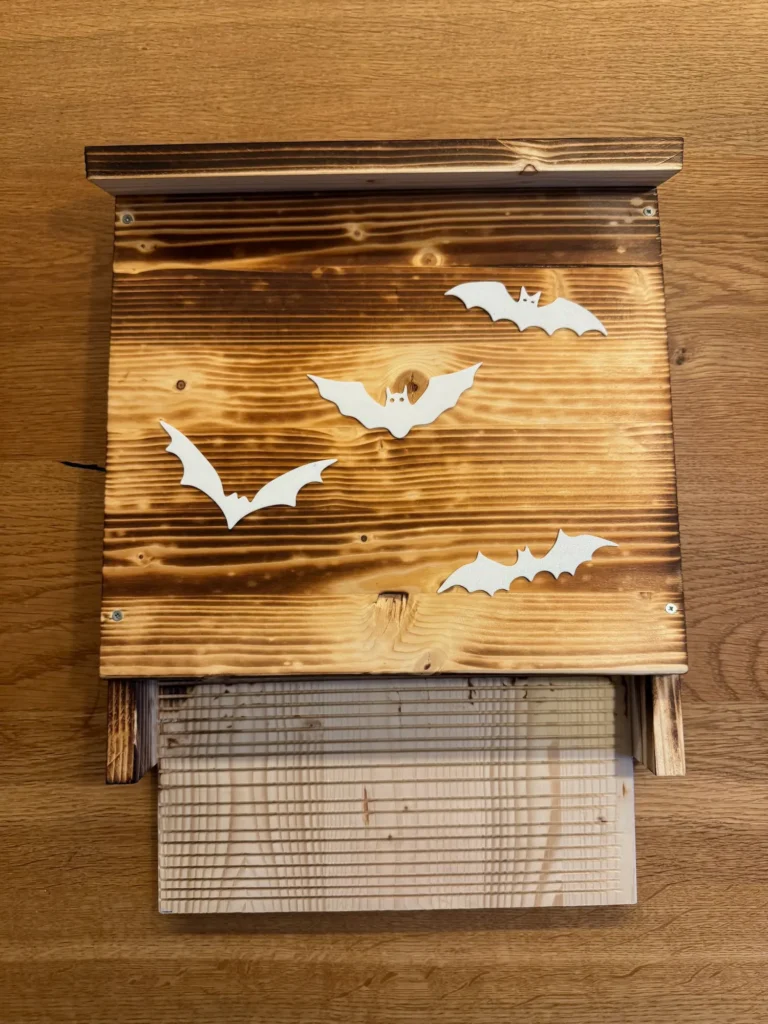Fledermauskasten aus Holz. Er wurde mir weißen Fledermäusen aus dem 3D-Drucker verziert.