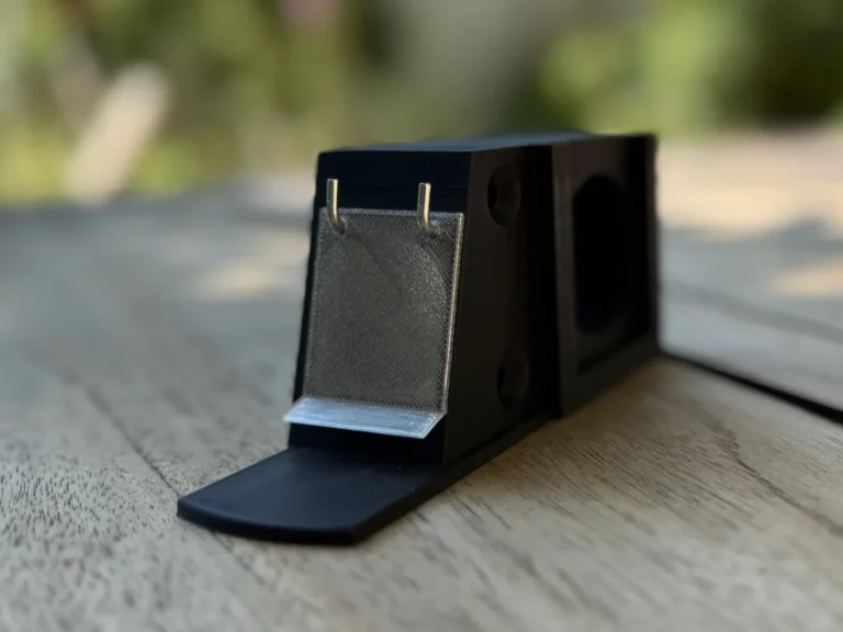 3D-Druck: Hummelklappenvorbau mit Wachsmottenklappe Schwarzer Vorbau mit montierter transparenter Klappe, befestigt mit zwei kleinen L-Haken.