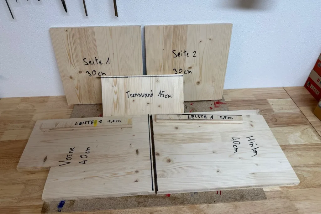 Alle zugeschnittenen Holzteile für das Igelhaus, beschriftet und bereit zum Zusammenbau.