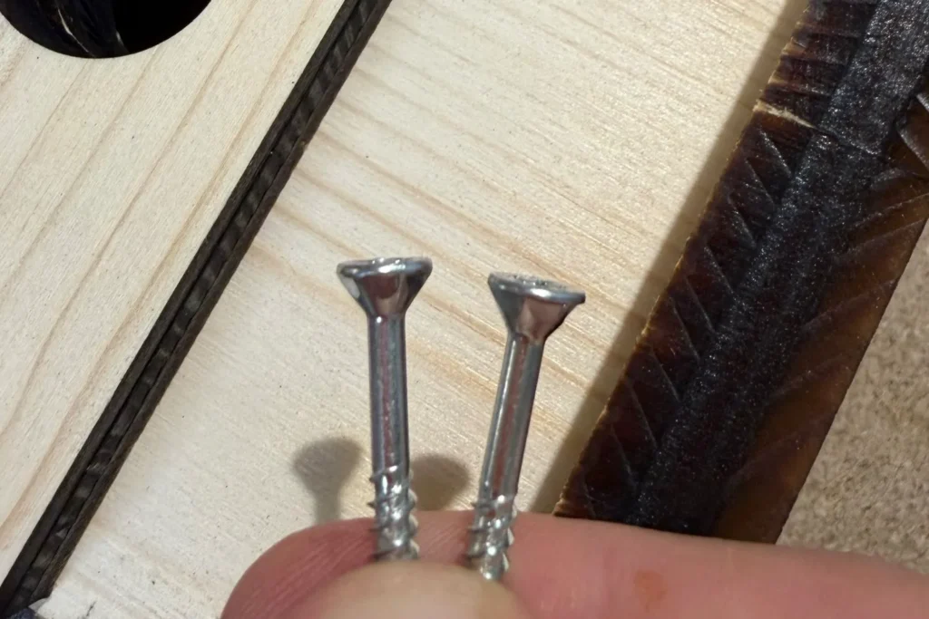 Detailaufnahme von zwei Schrauben mit Teilgewinde für den Nistkastenbau.
