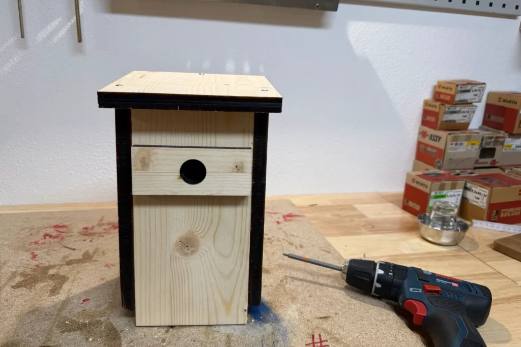 Selbstgebauter Höhlenbrüter-Nistkasten aus Holz mit Einflugloch und Dachüberstand.