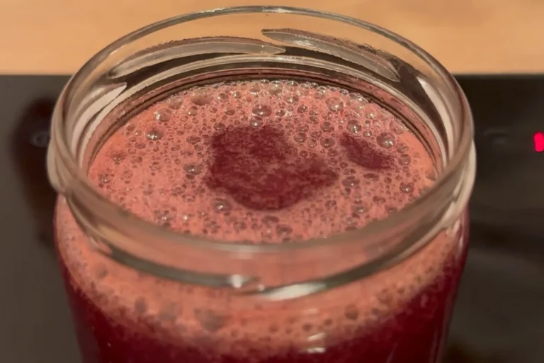 Heiße Weintraubenmarmelade frisch in ein Glas abgefüllt.