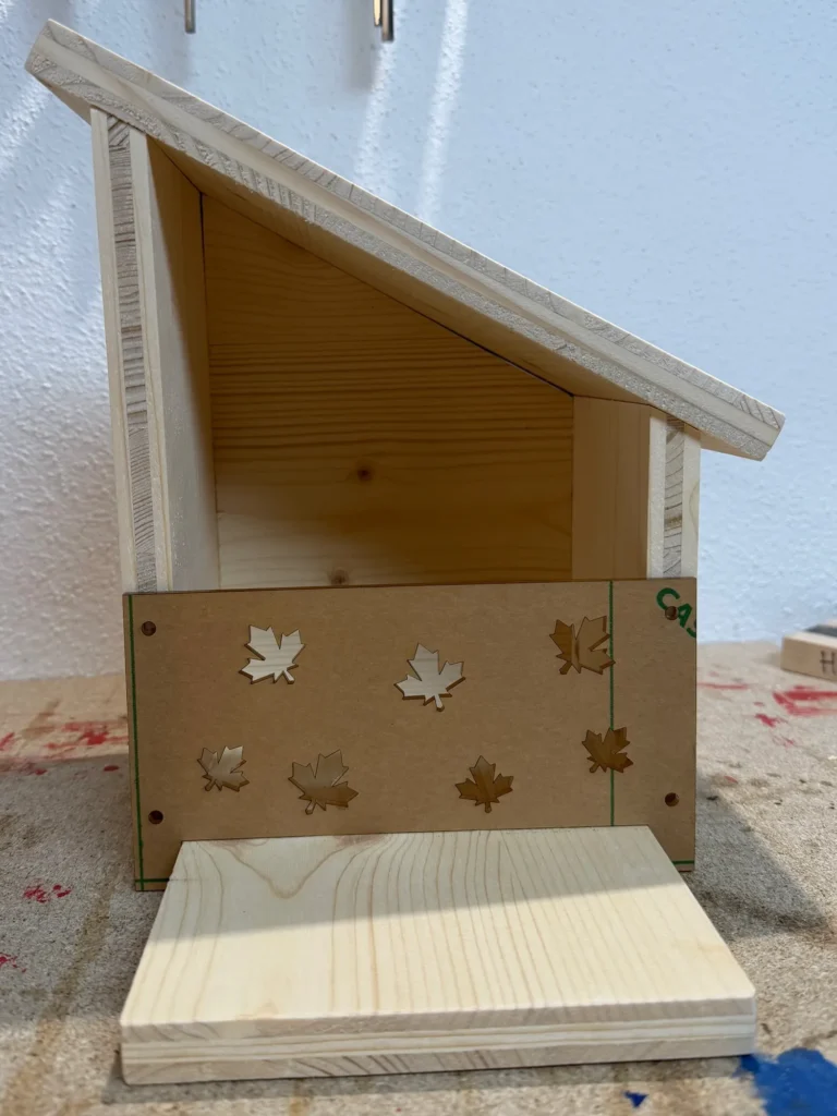 Fast fertiges Eichhörnchen-Futterhaus mit dekorativer Front und Blatt-Ausschnitten.