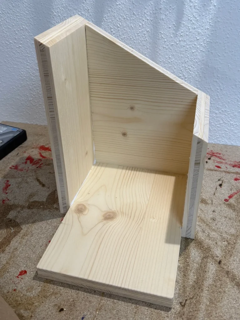 Schritt-für-Schritt-Montage des Bodens beim Eichhörnchen-Futterhaus aus Holz.