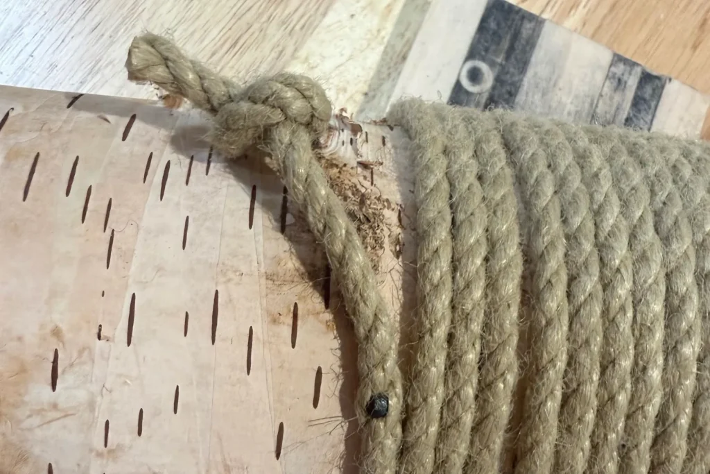 Sisal-Seil wird am Ende der Wicklung verknotet und mit einem Nagel fixiert.