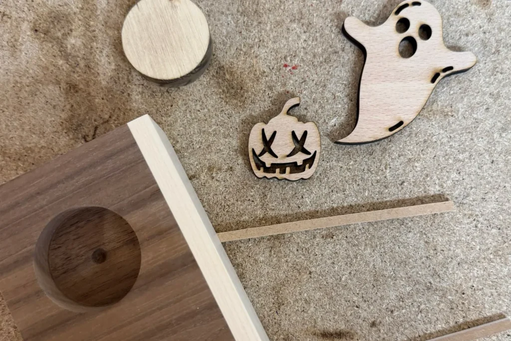 Ausgeschnittene Holzformen Geist und Kürbis als Halloween-Motive für den Teelichthalter.