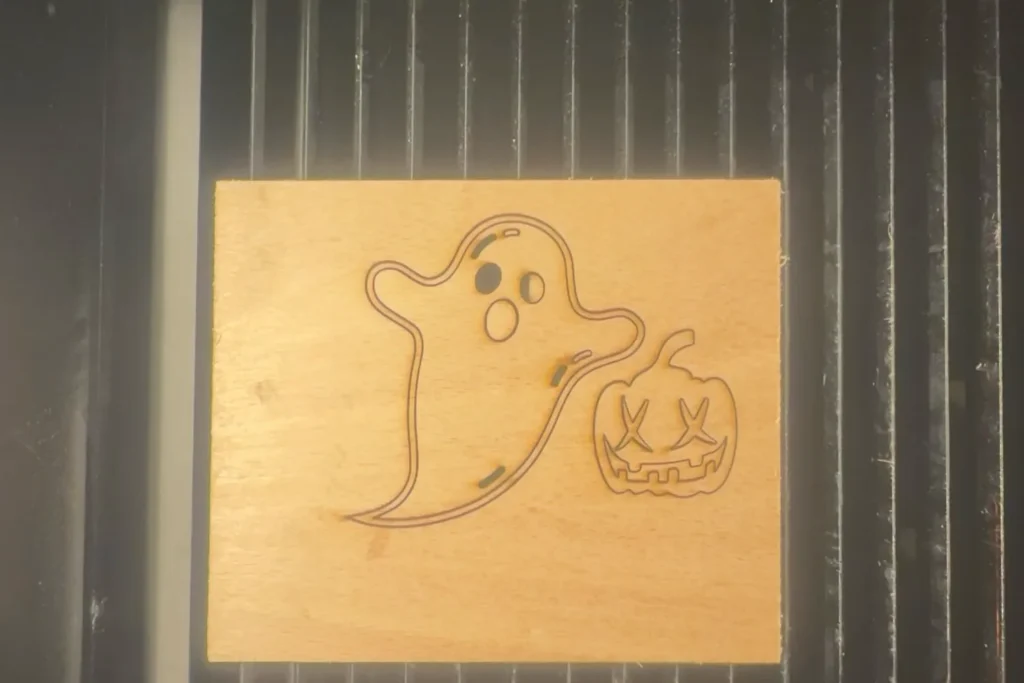 Der Laser schneidet die Halloween-Motive Geist und Kürbis präzise aus dem Sperrholz aus.