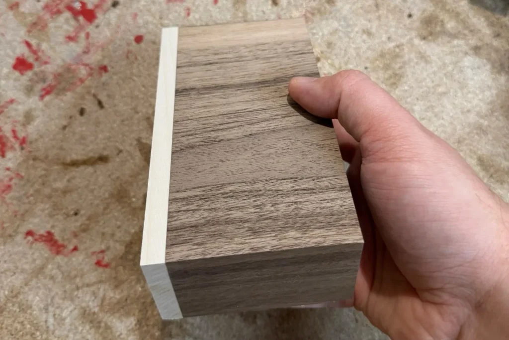 Geschliffener Holzblock mit kontrastreichem Übergang zwischen Walnuss und Ahorn.