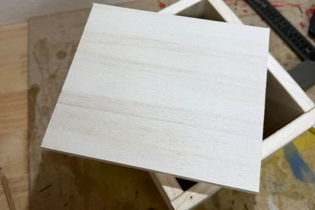 Zugesägte Bodenplatte aus Holz für ein selbstgebautes Schmetterlingshaus.