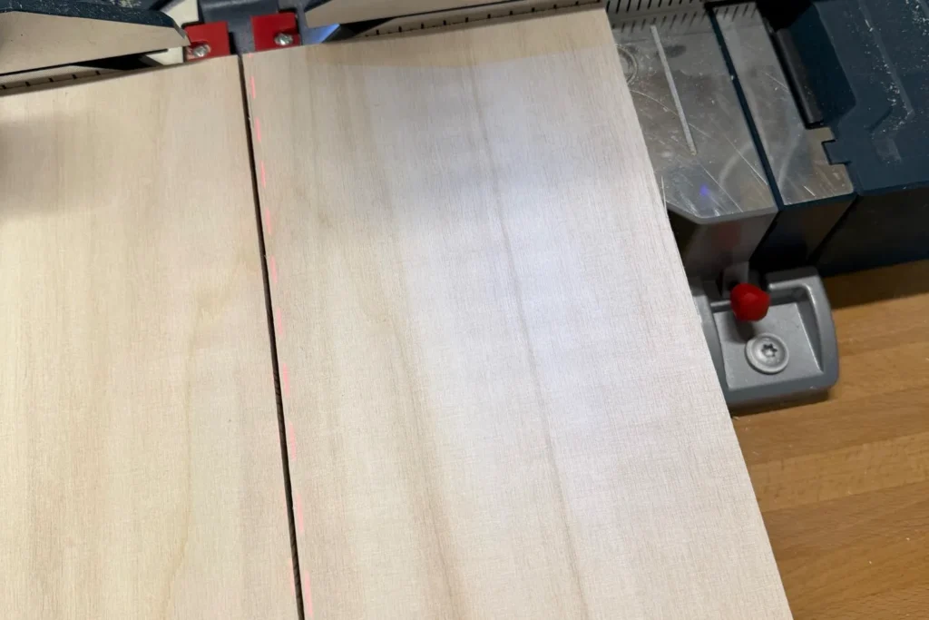 Zuschneiden einer Holzplatte für ein Schmetterlingshaus mit Laserführung.