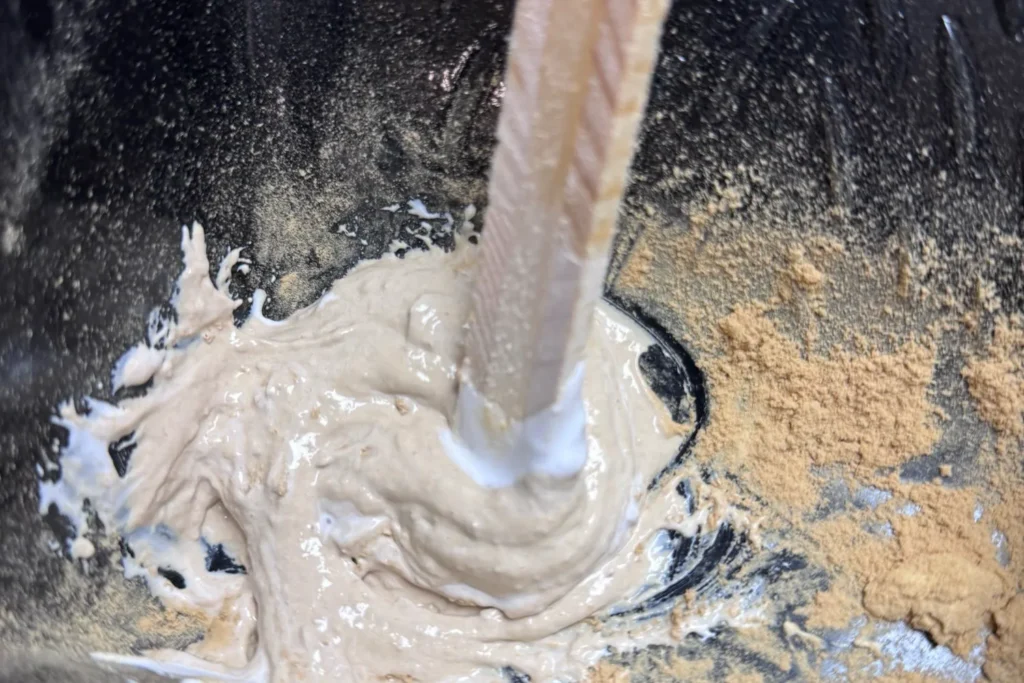 Nahaufnahme der cremigen Holzmehl-Leim-Mischung während des Anrührens