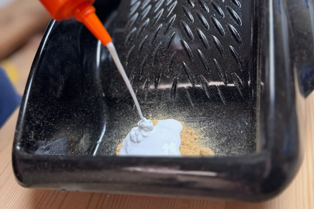 Holzmehl und Holzleim werden in einer Mischschale zusammengegeben.