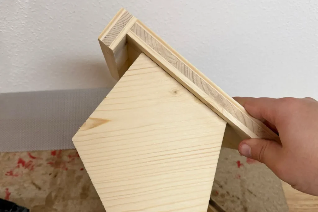 Vogelfutterhaus im Zusammenbau: Dachmodul sitzt lose auf dem Bodenrahmen vor der Verschraubung.