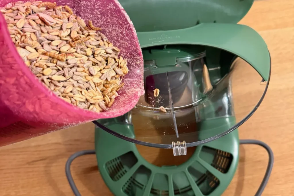 Vogelfutter wird in das geschützte Futtersilo des Birdfy Feeder 2 Pro eingefüllt