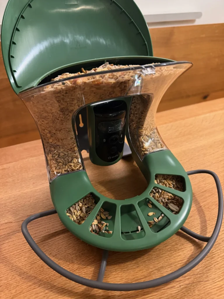 Birdfy Feeder 2 Pro Vogelfutterhaus mit Kamera, befüllt mit Vogelfutter und geöffnetem Deckel