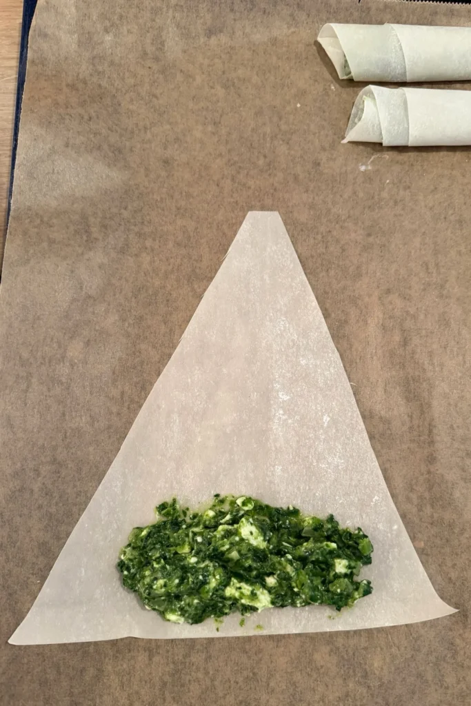 Spinat-Feta-Füllung wird auf Yufkateig verteilt – Vorbereitung zum Rollen der Börek.
