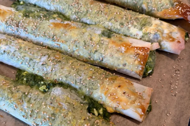 Knusprig gebackene Börek mit Spinat und Feta, mit Eigelb bestrichen und mit Sesam bestreut.