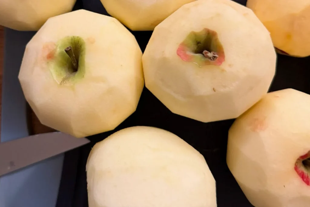 Mehrere geschälte Äpfel liegen bereit für die Zubereitung eines Apfelkuchens.
