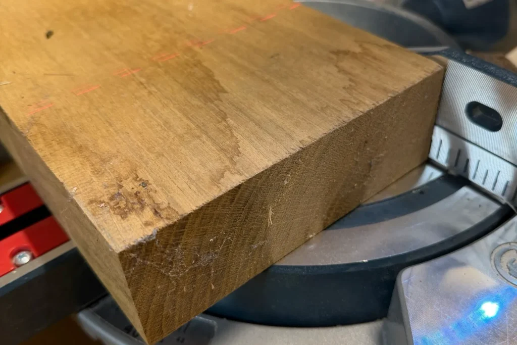 Eichenblock auf der Kappsäge, bereit für den Zuschnitt der späteren Teelichtwürfel.