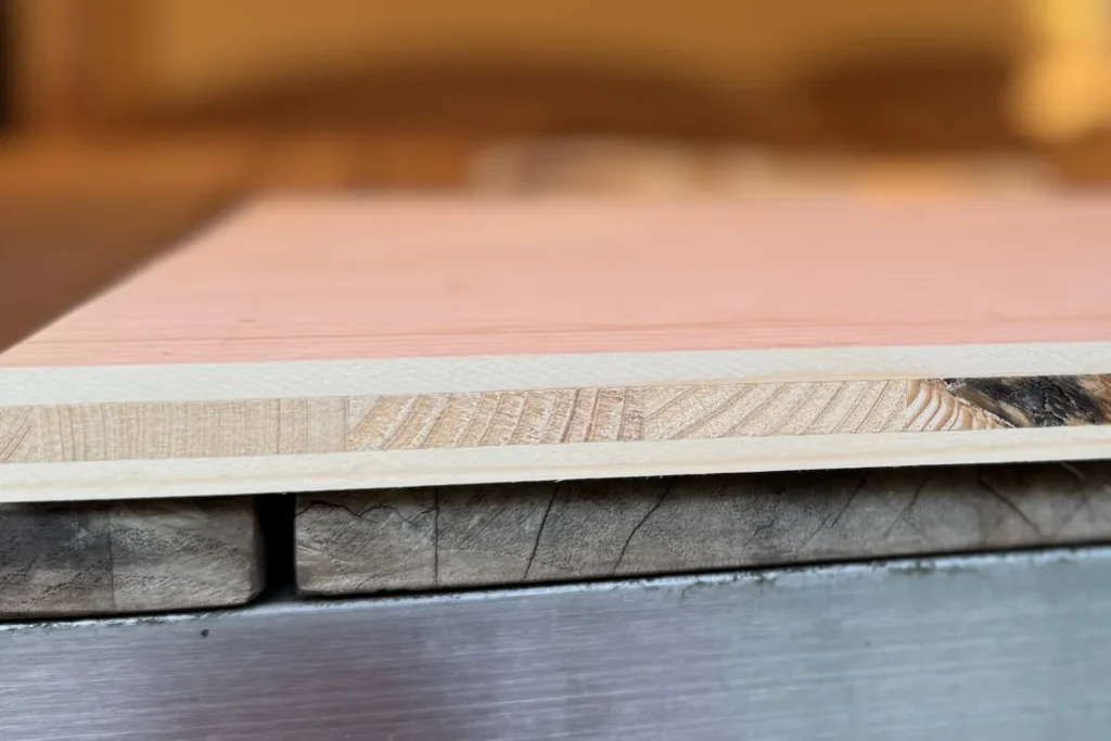 Detailansicht einer 3-Schicht-Fichtenplatte, die für den Bau einer Wildbienen-Nisthilfe verwendet wird