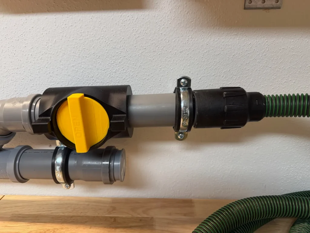 Nahaufnahme eines Blastgates mit Adapterstück von DN50 PP-Rohr auf antistatischen 50-mm-Absaugschlauch.