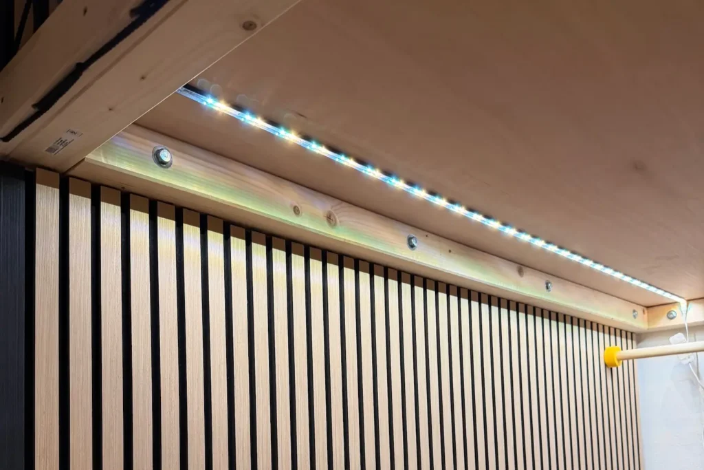 Indirekte LED-Beleuchtung unter einem DIY-Hochbett mit Holzlamellen an der Wand