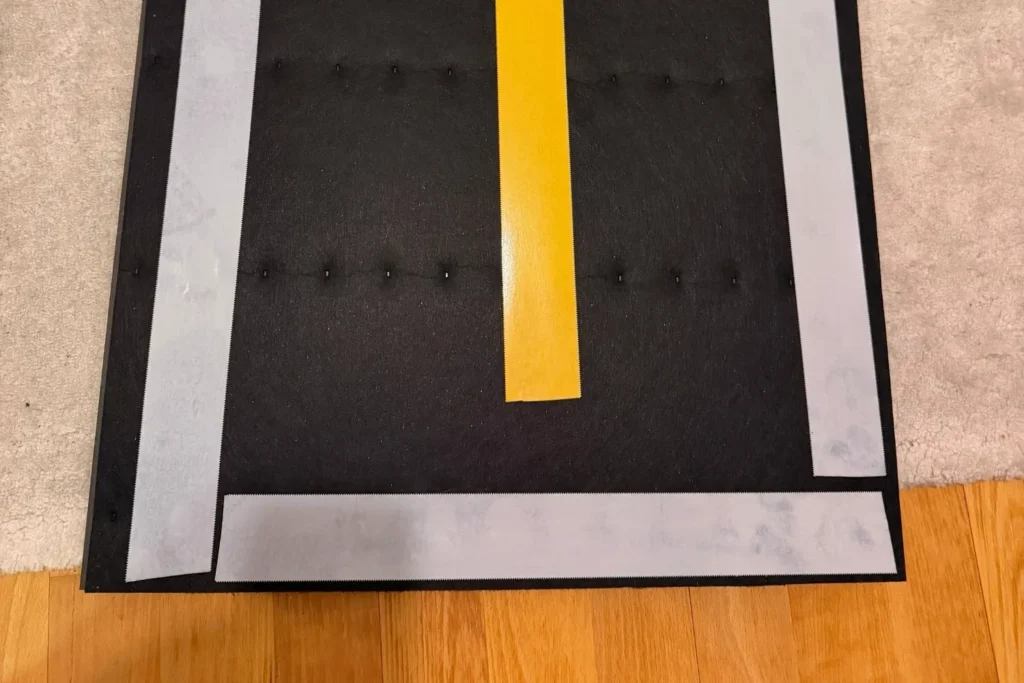 Rückseite eines Akustikpaneels mit Klebeband und Filzschicht vor der Montage.