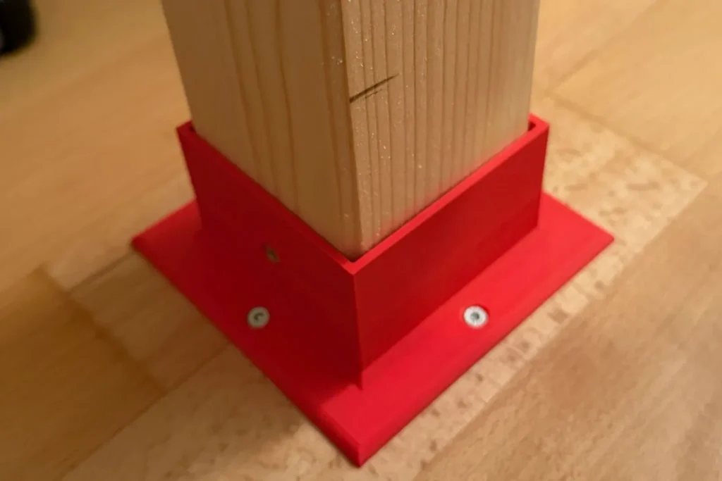Roter Pfostenschuh aus dem 3D-Druck zur sicheren Befestigung des Holzpfostens eines Hochbetts.