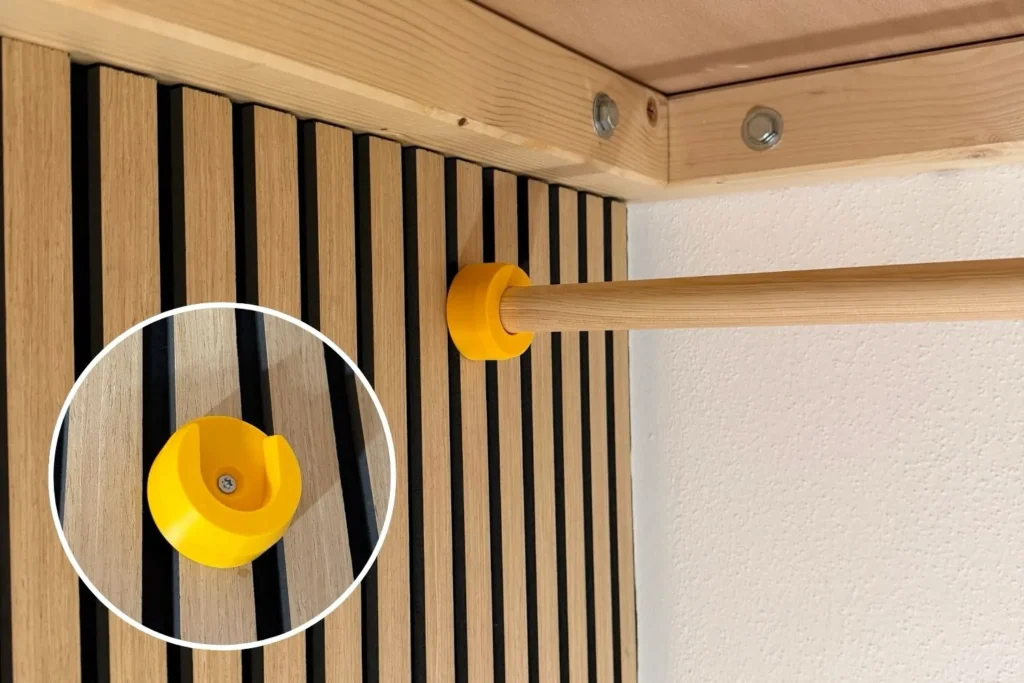 Gelbe Halterung aus dem 3D-Druck für eine Kleiderstange unter einem Hochbett.