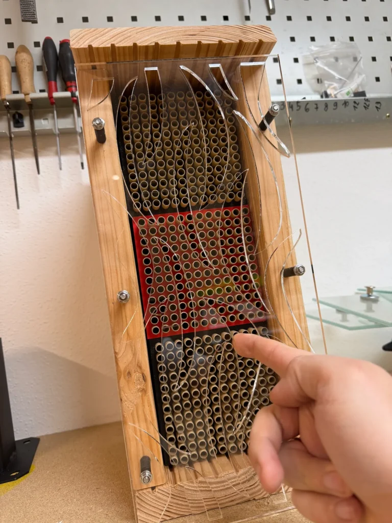 „Modulare Wildbienen-Nisthilfe mit austauschbaren Niströhrchen hinter transparenter Schutzscheibe