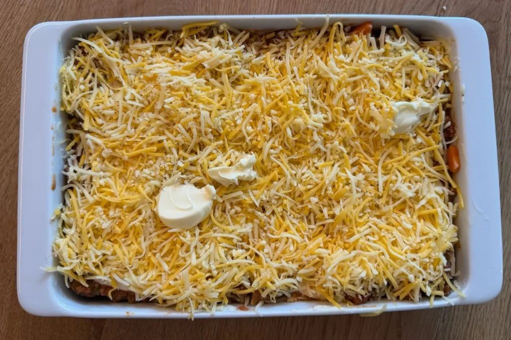 Lasagne mit Rinderhack und Béchamel vor dem Backen mit Käse bestreut