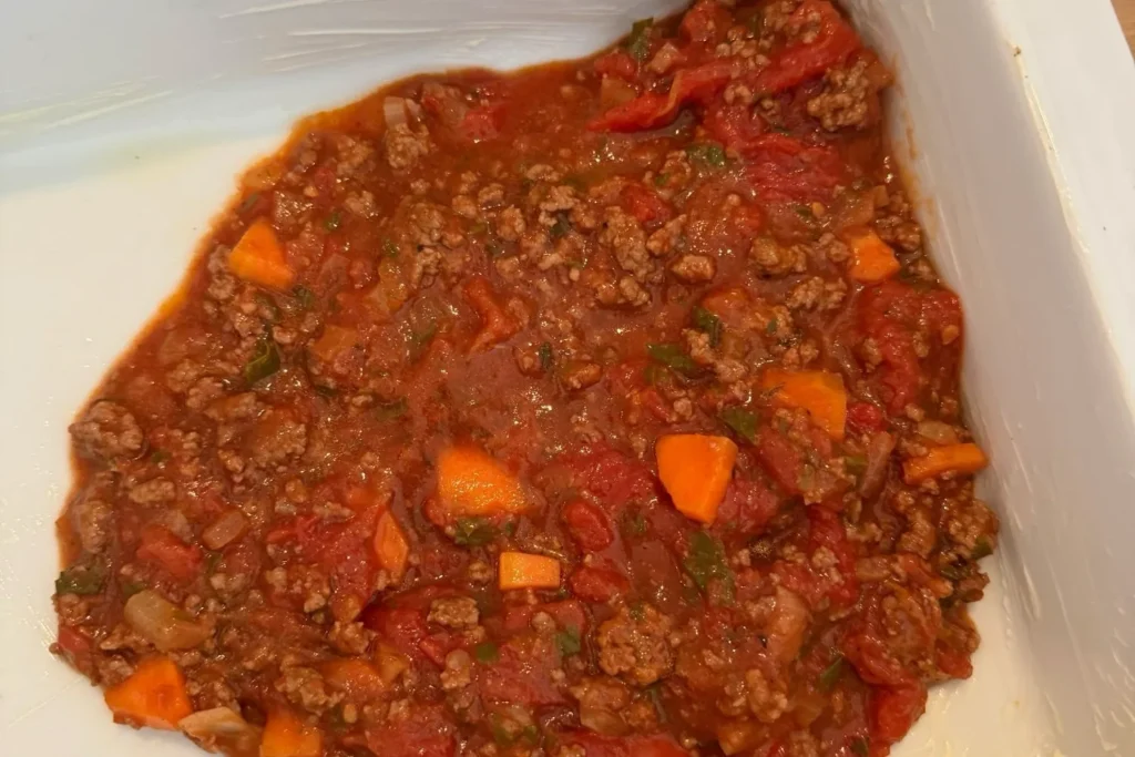 Rinderhack-Bolognese mit Karotten gleichmäßig in der Auflaufform verteilt