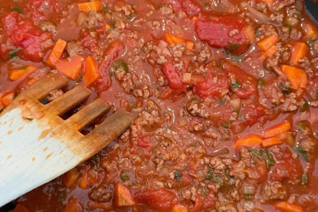 Rinderhack-Bolognese mit Karotten wird in der Pfanne langsam eingekocht