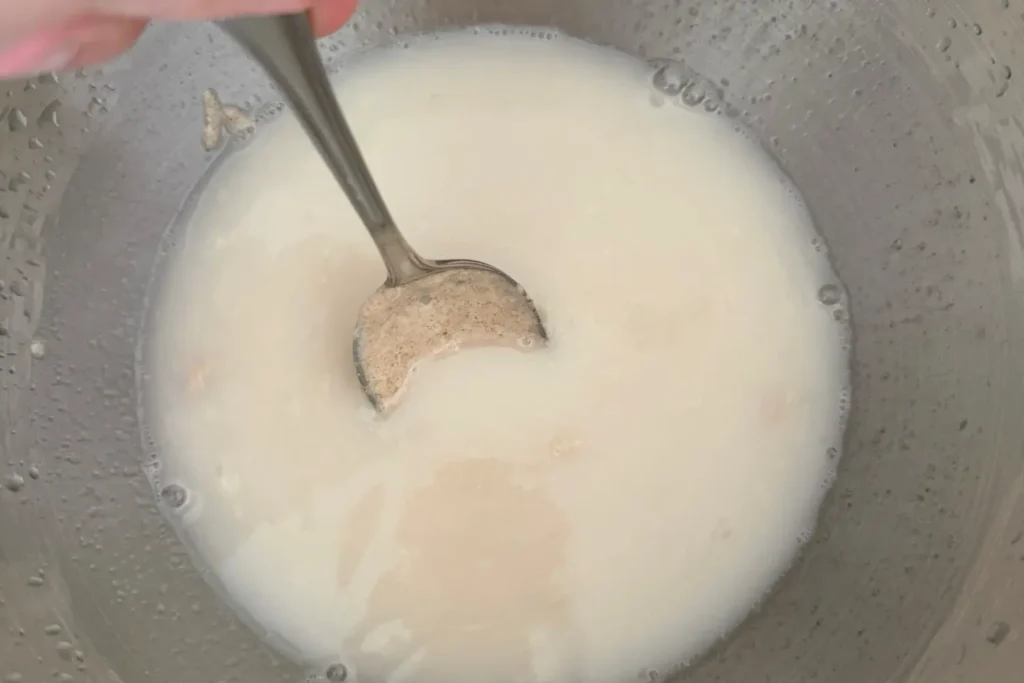 Anstellgut wird in Wasser mit einem Löffel aufgelöst