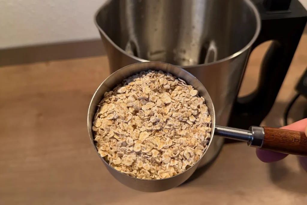 Abgemessene Haferflocken für selbstgemachte Hafermilch im Messbecher vor dem Mylky Pflanzenmilchbereiter