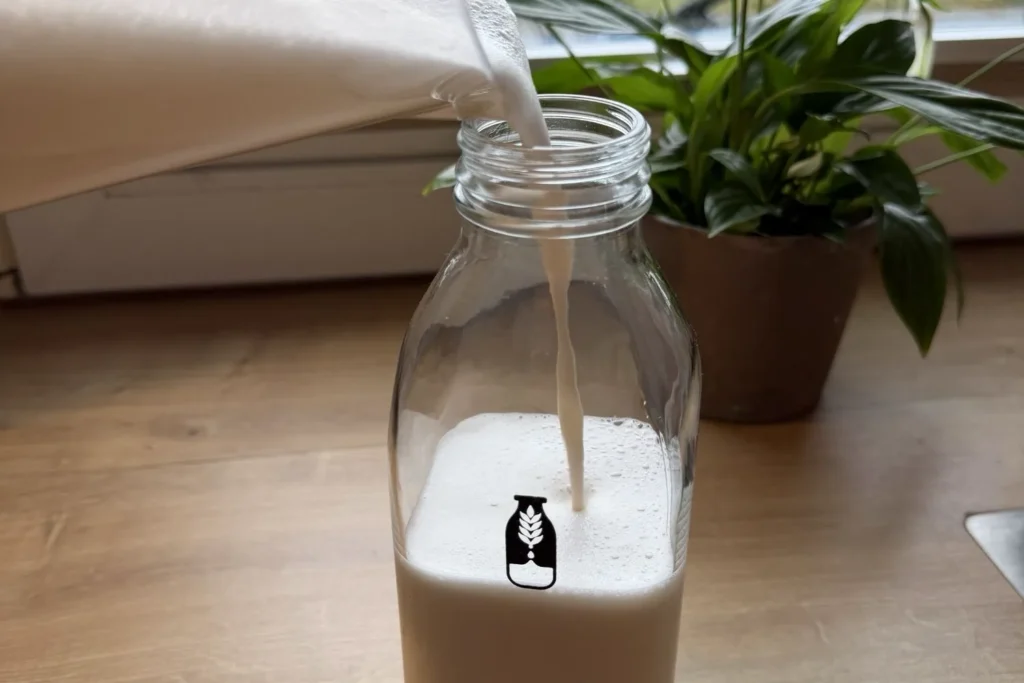 Frisch gemachte Mandelmilch in Glasflasche abfüllen