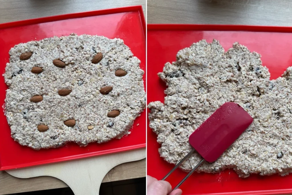 Müsliriegel-Masse wird auf einer Backmatte verteilt und glatt gestrichen