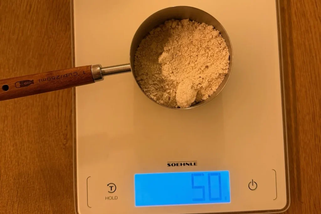 Roggenmehl wird mit Küchenwaage für Sauerteig Starter abgewogen