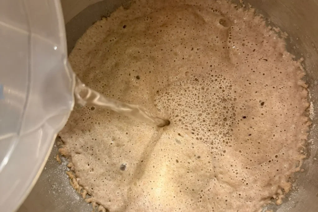 Wasser wird zum Sauerteig für den Hauptteig hinzugegeben