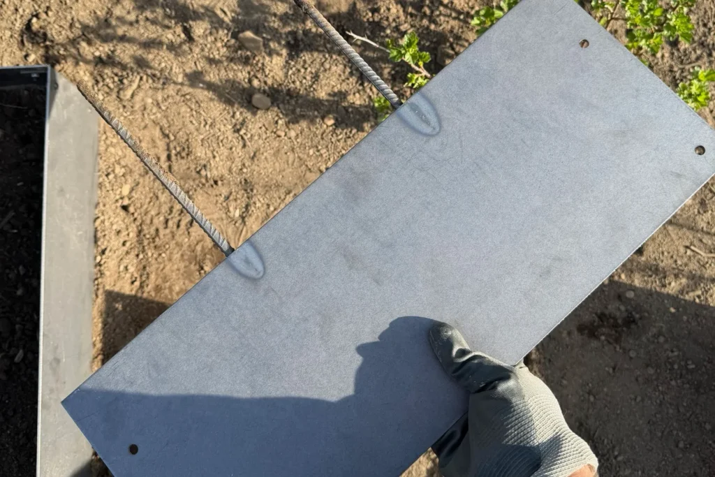 Detailaufnahme eines einzelnen Elements einer Beeteinfassung aus Cortenstahl im Schrebergarten