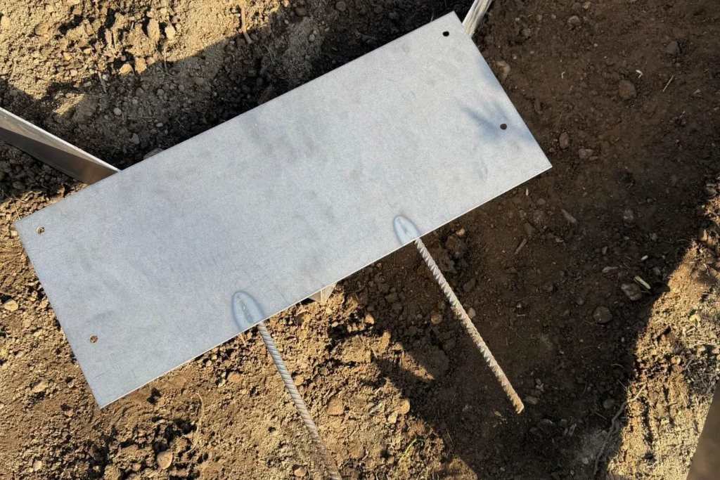 Frisches Cortenstahl-Element ohne Rostpatina vor dem Einbau im Gartenbeet