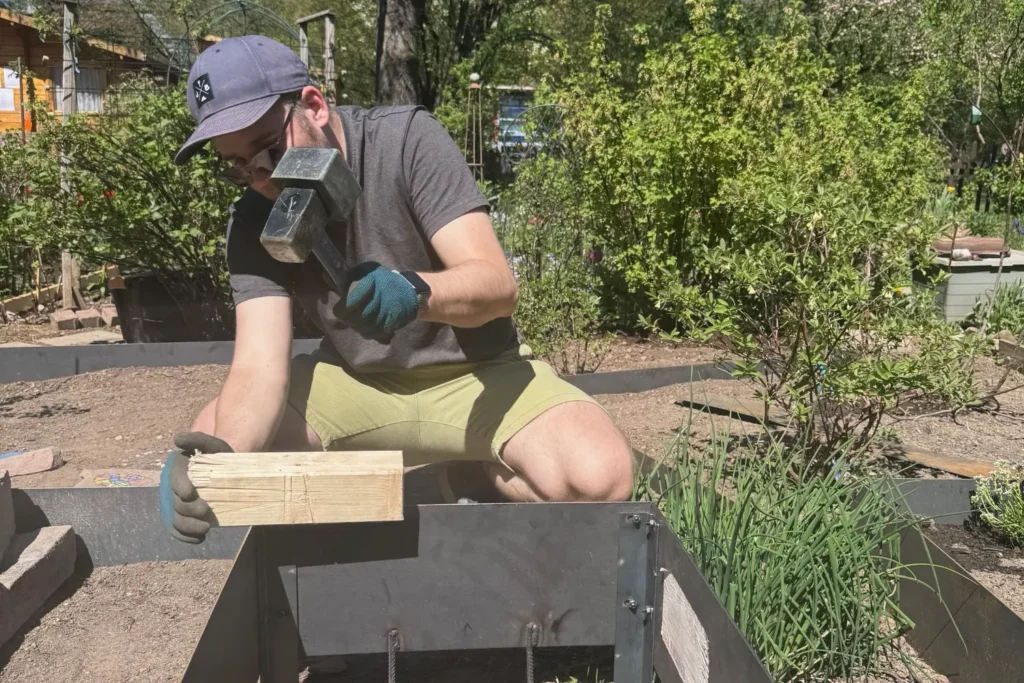 Cortenstahlrahmen wird beim Aufbau mit Werkzeug ausgerichtet und fixiert