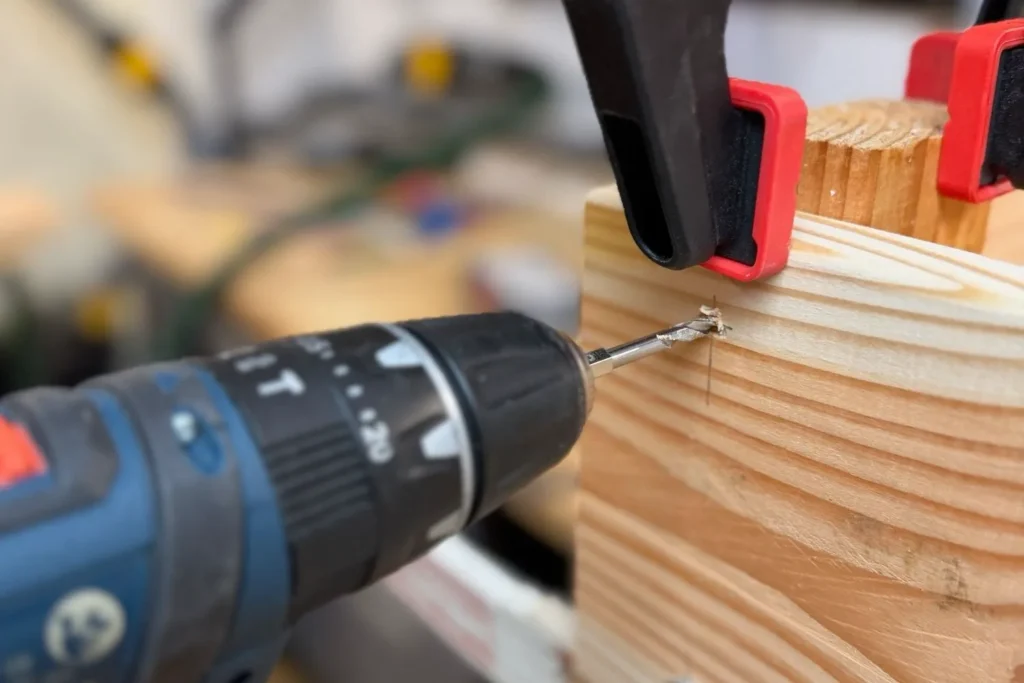 Holz wird mit Akkuschrauber vorgebohrt für saubere Verschraubung beim Hochbeet