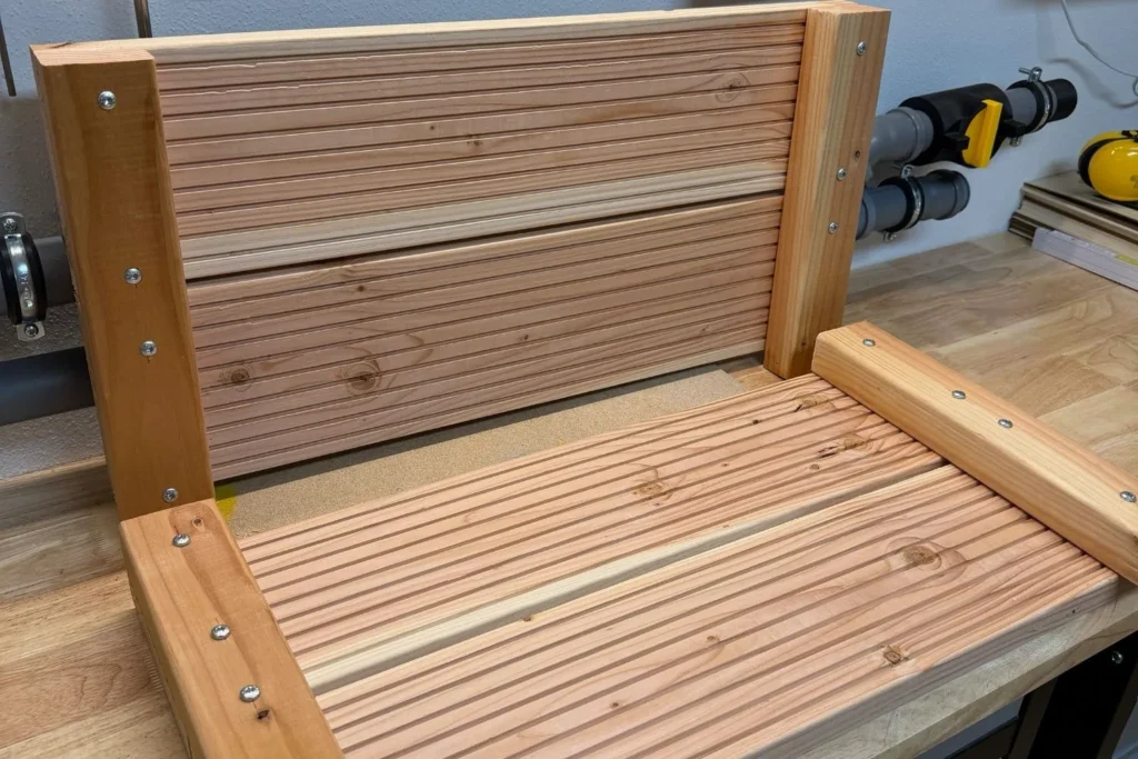 Zwei fertige Seitenteile eines Hochbeets aus Holz liegen nebeneinander