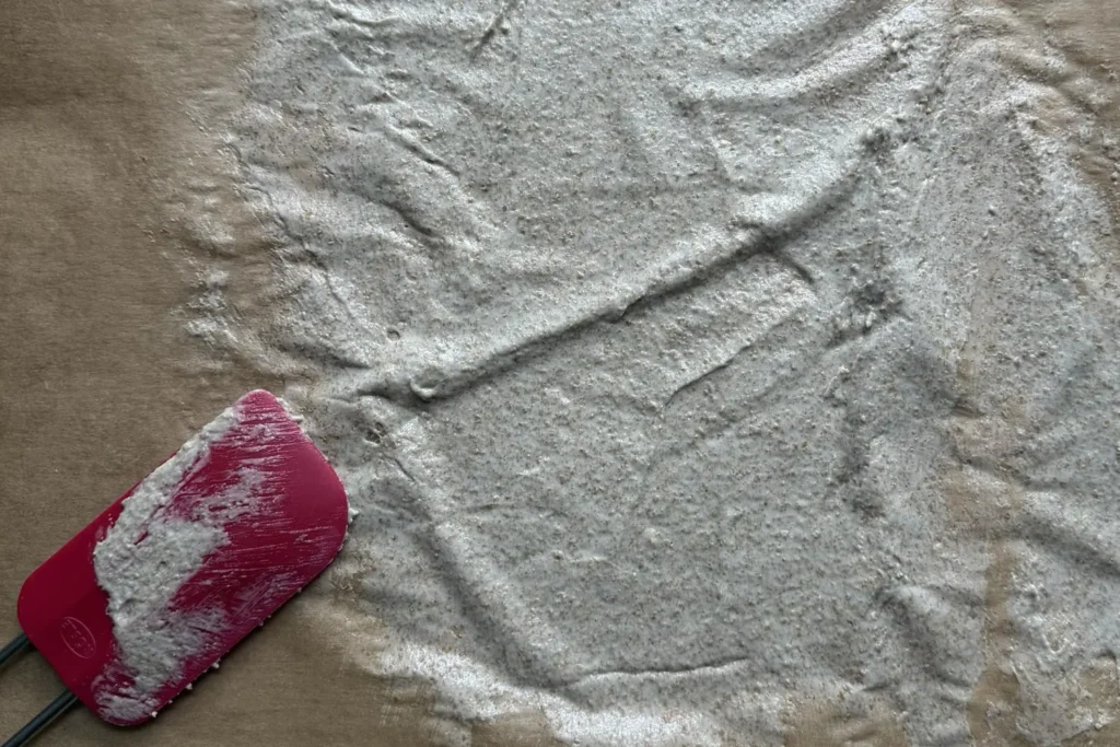 Sauerteig wird dünn auf Backpapier ausgestrichen zum Trocknen